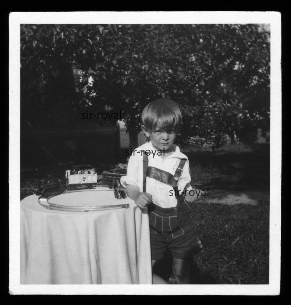 Boy in Leather Trousers with Toy Train – Photo 6x6cm