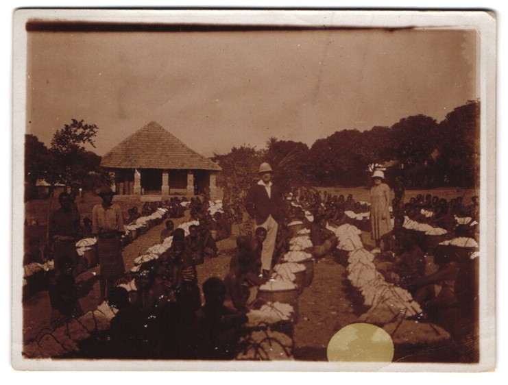 Photograph African locals picking cotton monitored by colon