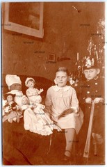 Boy in Military Uniform with Shako and Girl with Dolls – Photo Postcard 9x14cm