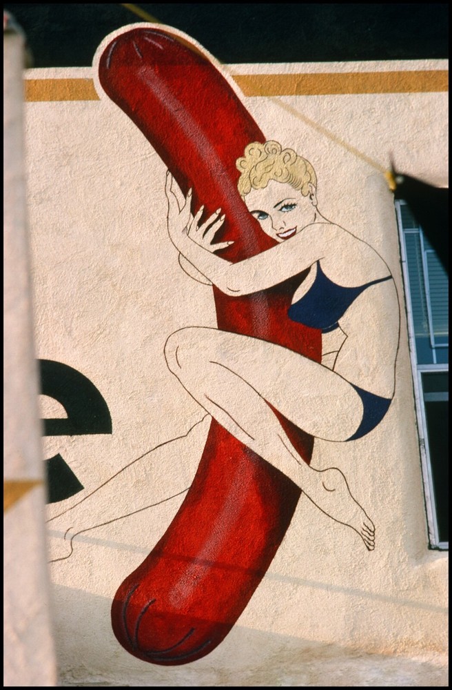 HOLLWOOD WALL GRAPHIC OF A GIRL HUGGING A HOT DOG. JULY 1977