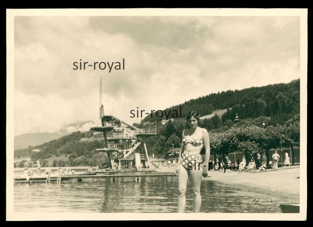 Pretty woman in bikini in front of diving tower in outdoor pool – 1960s – photo 10x7cm