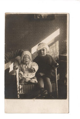 13280 – Photo * 2 Little Girls in Wicker Chair * Dedication Easter around 1915