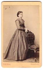 Photograph Joh. Rooster, Nuremberg, young lady in striped dress standing at chair