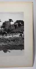 J.W. Howlett Black + white Photograph focusing on a Group of Travelers W/ Camel