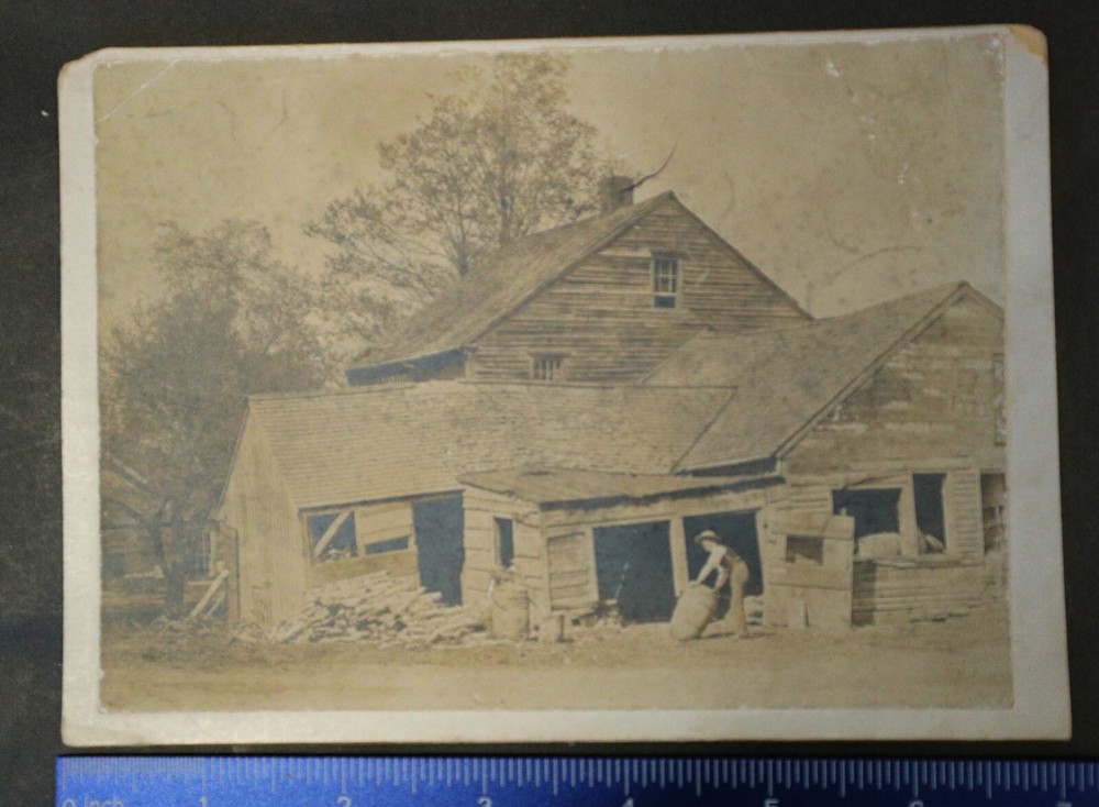 Photograph on Card, 7×5, man rolling out a barrel from building