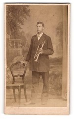 Photograph Young Man as Musician with Trumpet in Front of a Studio Backdrop