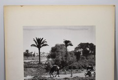 J.W. Howlett Black + white Photograph focusing on a Group of Travelers W/ Camel