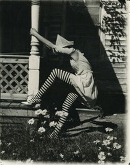 Woman in striped stockings newspaper hat climbing porch strange art large photo
