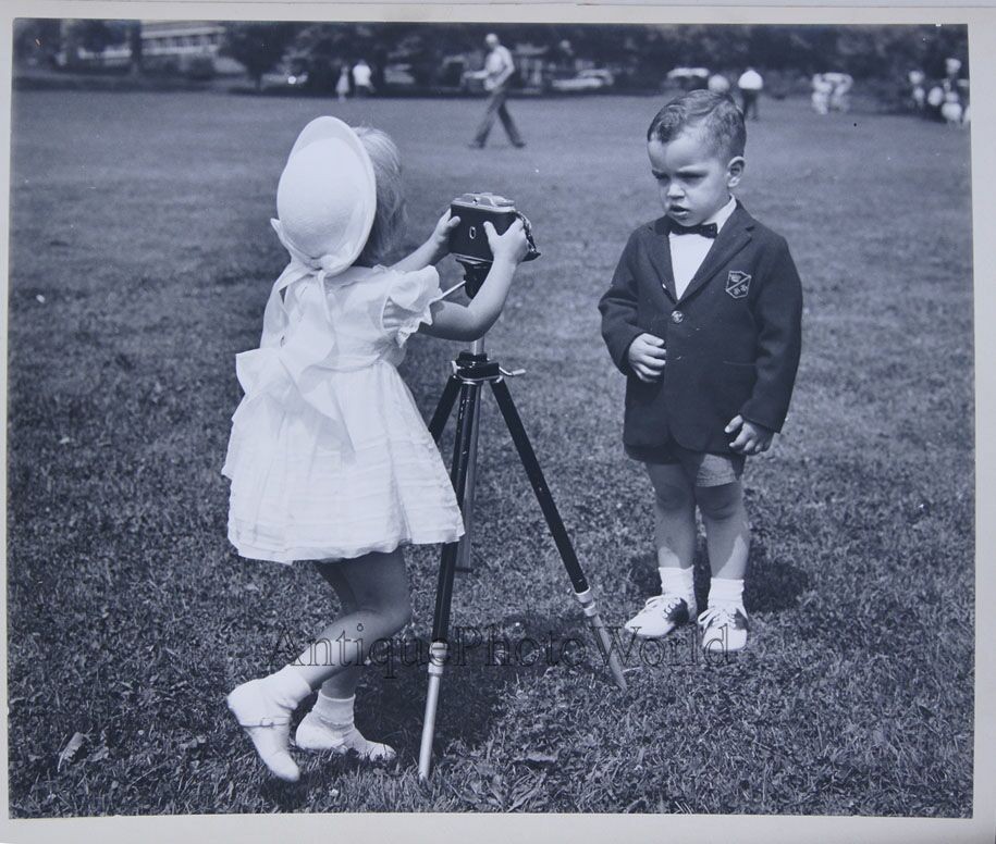 Children girl photographer w camera taking a photo of a boy vintage art photo