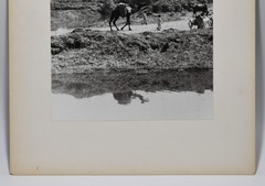J.W. Howlett Black + white Photograph focusing on a Group of Travelers W/ Camel