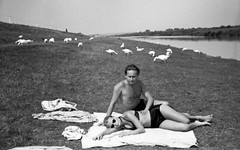 young couple in swimsuits, geese on riverside, unusual vintage fine art negative