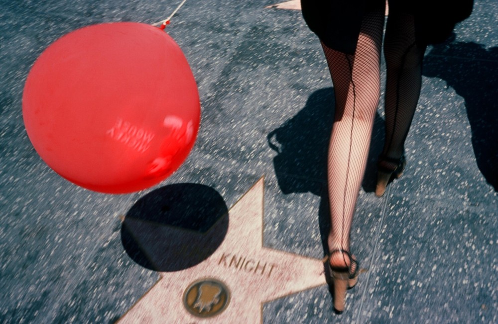 HOLLYWOOD BOULVEVARD: WOMAN IN NET STOCKINGS AND MICKEY MOUSE BALLOON. JULY 1976