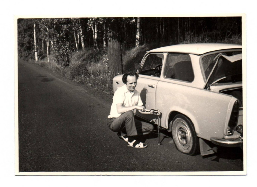Photo of early man Trabant changing wheels country road Trabbi vintage 1973