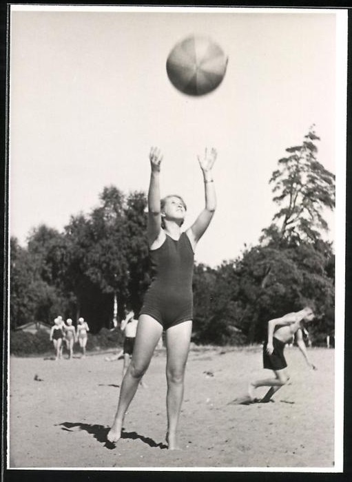 Photograph Young Woman in Swimsuit Playing with Beach Ball in Sand