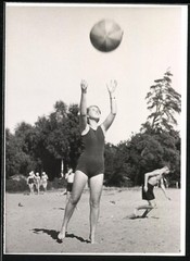 Photograph Young Woman in Swimsuit Playing with Beach Ball in Sand