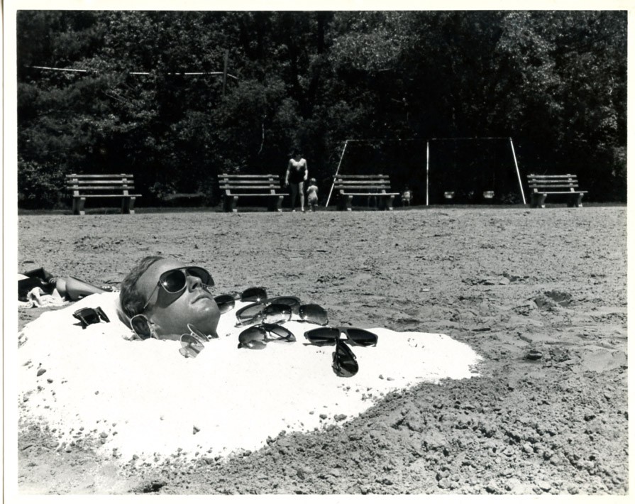 Man buried in sand posing with many sunglasses fun strange vintage art photo