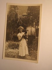 woman standing in garden with dog in arms / photo England