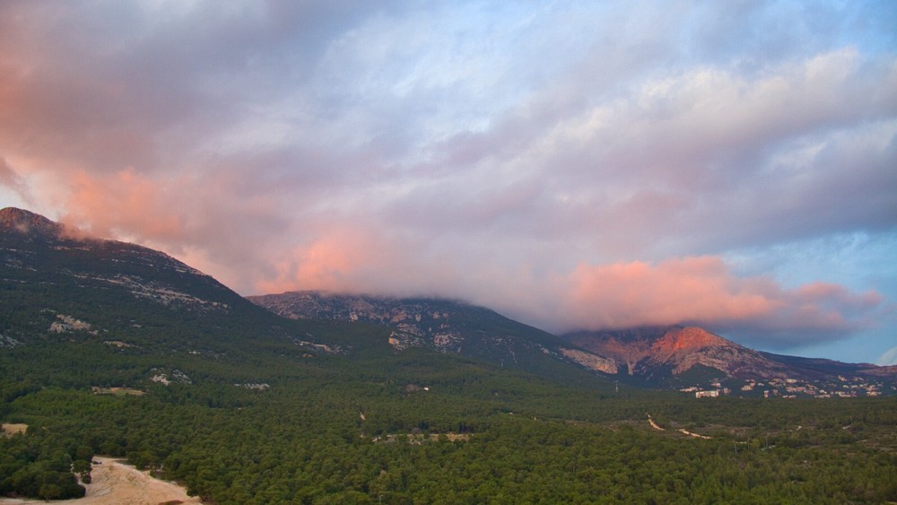 Calm mountains covered with pink clouds
