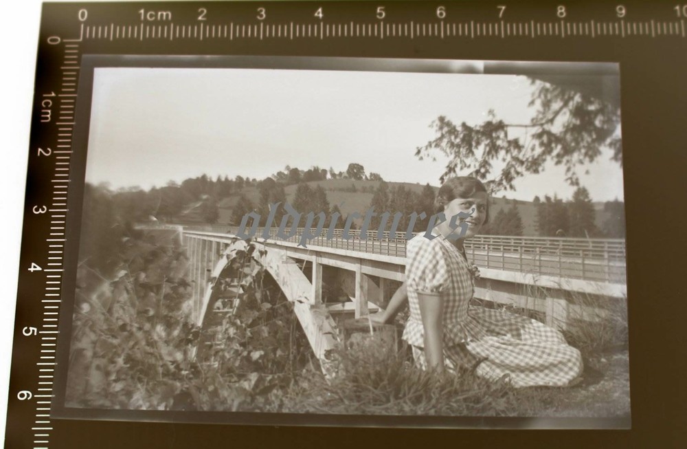 Great old negative – pretty woman posing at a railway bridge – place??