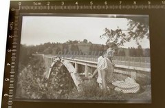 Great old negative – pretty woman posing at a railway bridge – place??
