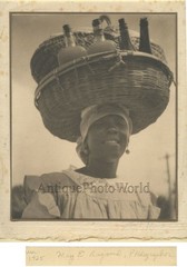 Woman carrying bottles on head antique art photo Caribbean