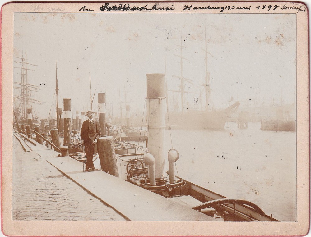 Photograph from 1898 of an elegant gentleman at the port in Hamburg, photo including steamer